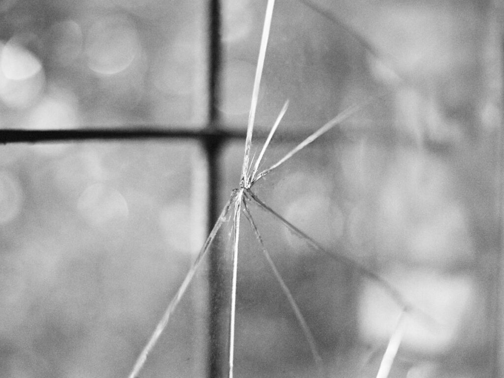 Close-up of cracked window glass with radiating fracture lines
